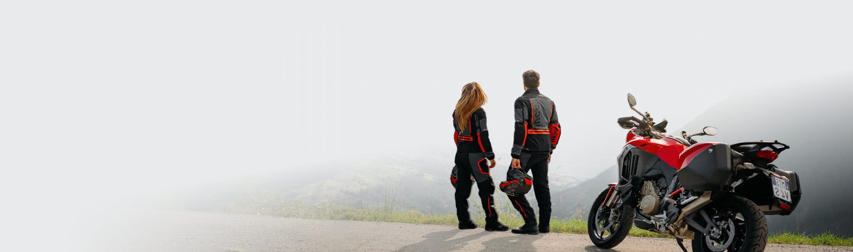 Dwoje motocyklistów podziwiających górski krajobraz z motocyklem
